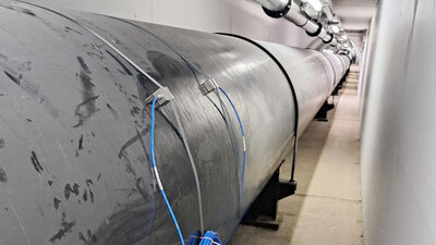 NIVUS NIC-CO Clamp-On Sensorpaar befestigt außerhalb eines Rohres mittels Metallbänder zur berührungslosen Messung der Fließgeschwindigkeit.